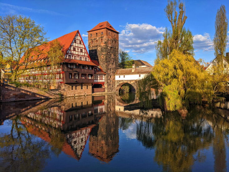 Blick auf eine Burg von Nürnberg, die sich im Wasser spiegelt