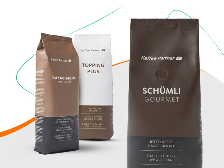 Drei Packungen von Kaffee Partner Produkten: Kakaotraum Premium, Topping Plus, Schümli Gourmet Röstkaffee