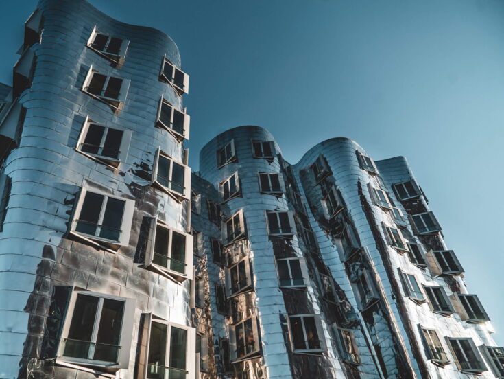 Wellenförmiges Gebäude mit silberner glänzender Fassade in Düsseldorf